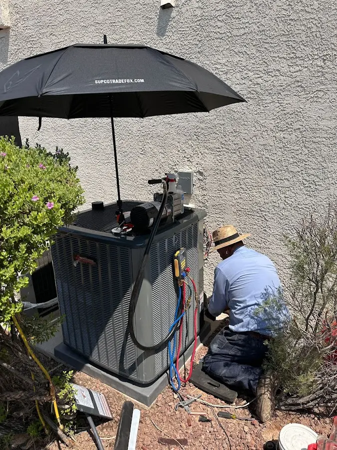 HVAC technician performing outdoor AC maintenance in Corcoran
